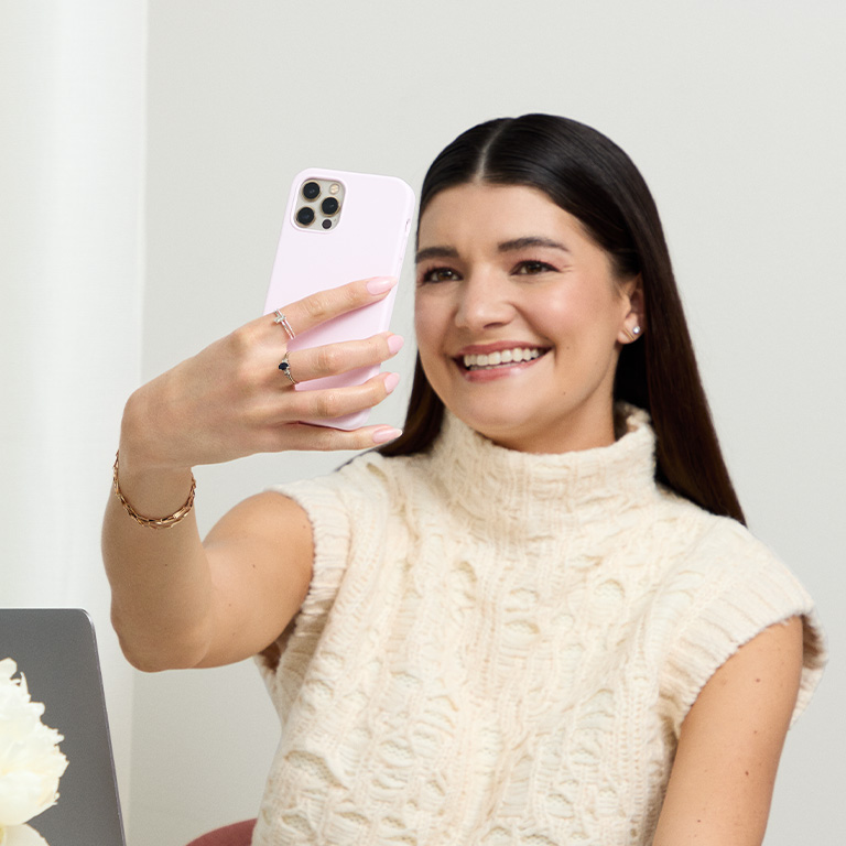 Woman smiling into her phone using the AI Foundation Finder tool